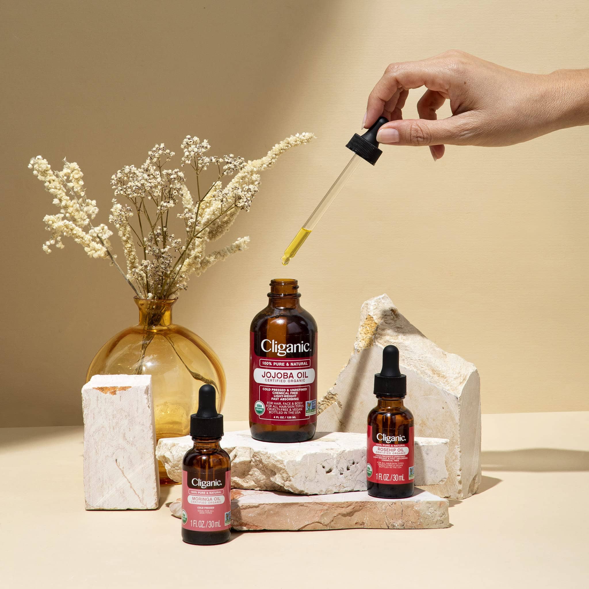 essential oils for gua shua on a table with a hand holding a dropper