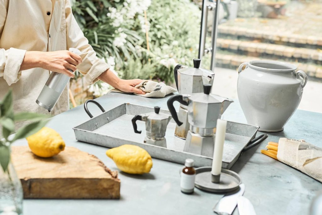 Cleaning a non toxic kitchen with a spray bottle, lemon, soap, vinegar, and essential oils