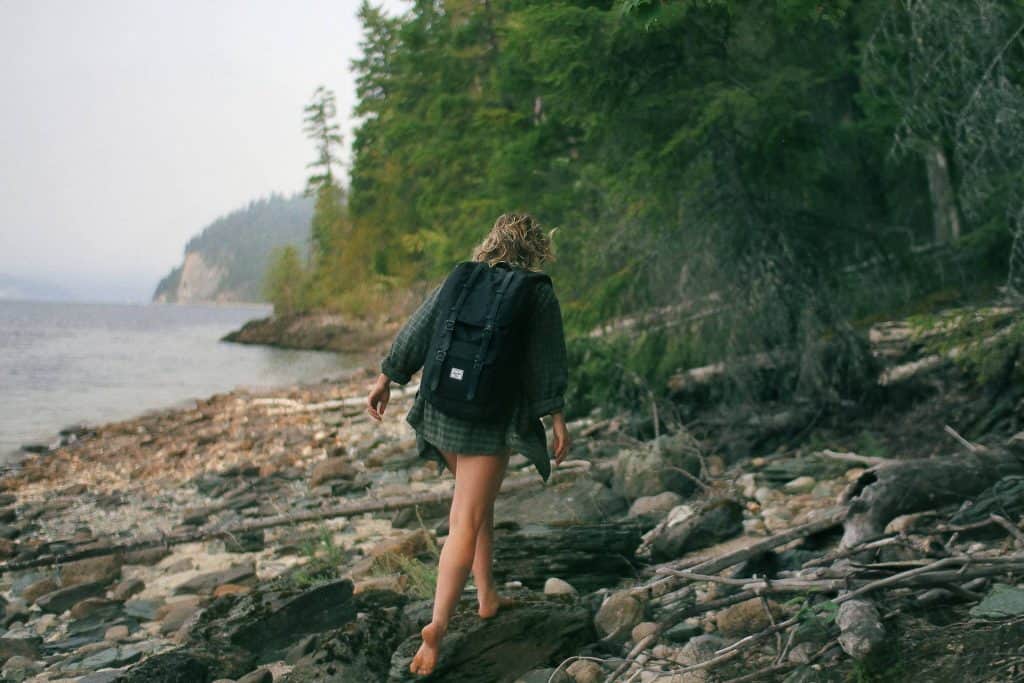 woman walking on shoreline barefoot