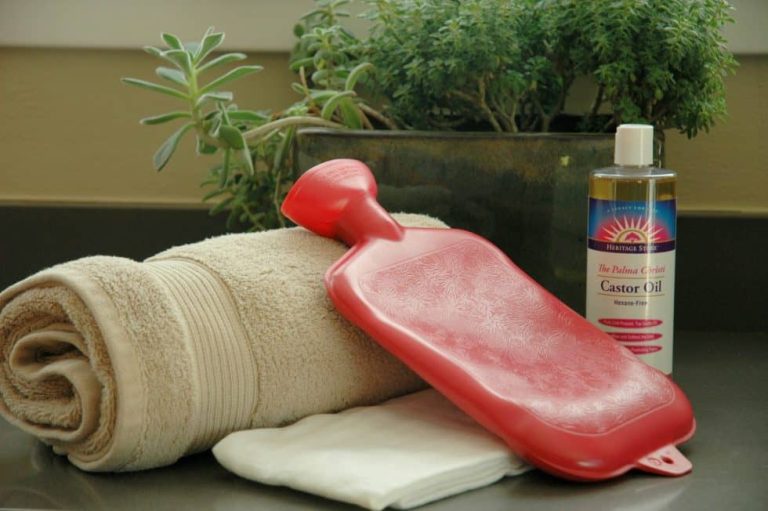 A towel, cloth, hot water bottle, and castor oil for making castor oil packs